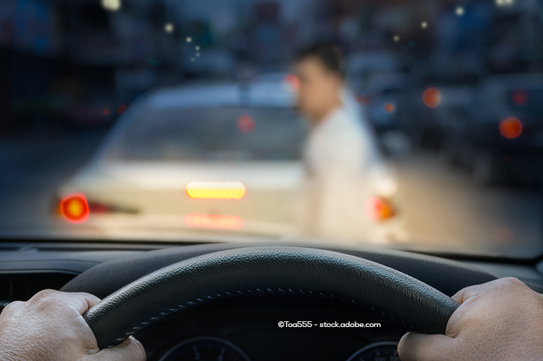 A driver grips a steering wheel as a pedestrian walks in front of his car. Model year 2011–2017 Honda Odysseys were targeted with several complaints about transmission clunks, hesitation during gear changes and juddering while using breaks.