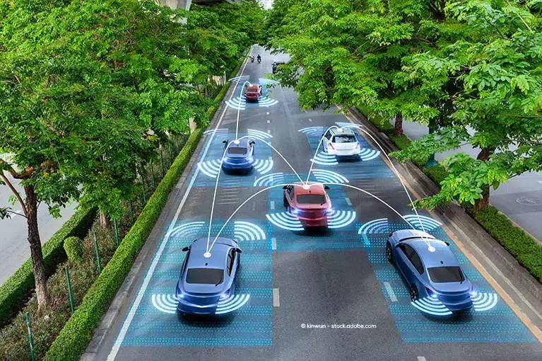 Red, white and blue cars are driving along a one-way road with three lanes. The road is lined by trees on both sides. Radar and sensor signals are visually represented here as an infographic tool for radar sensing systems installed in cars.