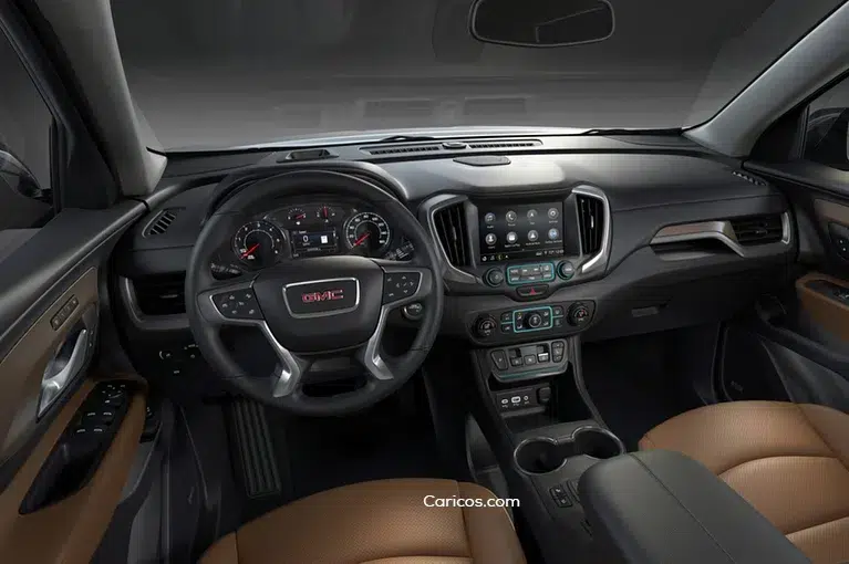 The interior of a GMC vehicle, with a view of the GMC logo on the steering wheel. The seats appear to be upholstered with brown leather, though most of the interior is black.