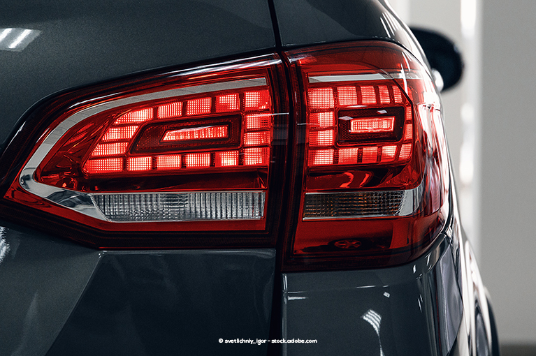 A lit up brake light on the rear end of a grey/black vehicle. Several 2015 and newer Nissan models come with faulty “Forward Emergency Braking” or “Automatic Emergency Braking” systems. 