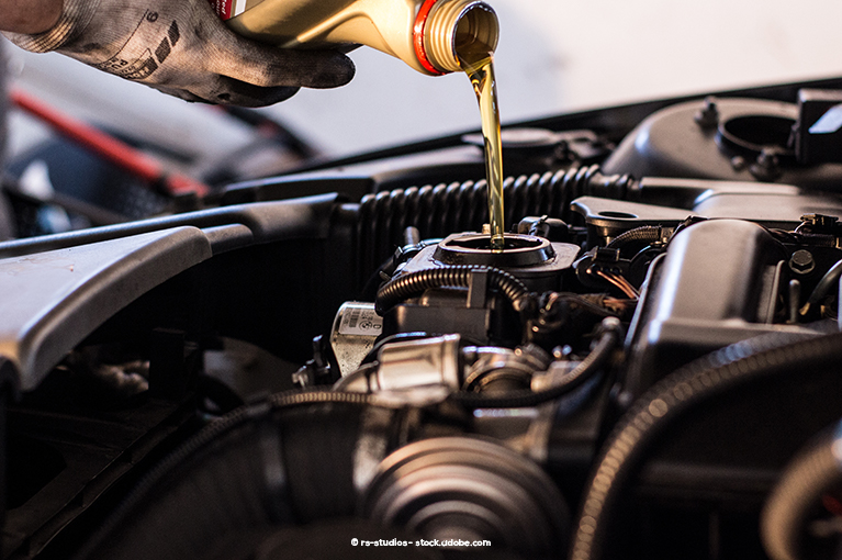 Yellow engine oil is being poured into the engine.