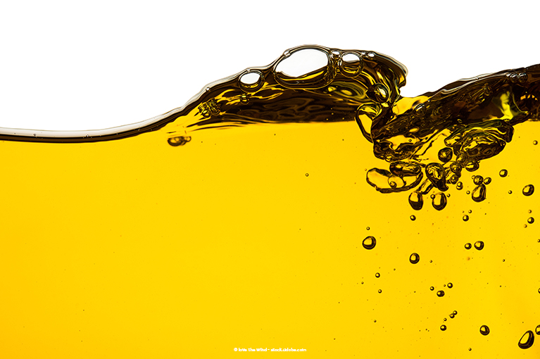 Yellow oil seems to fill a container. It bubbles and sloshes, as if the container itself has moved.