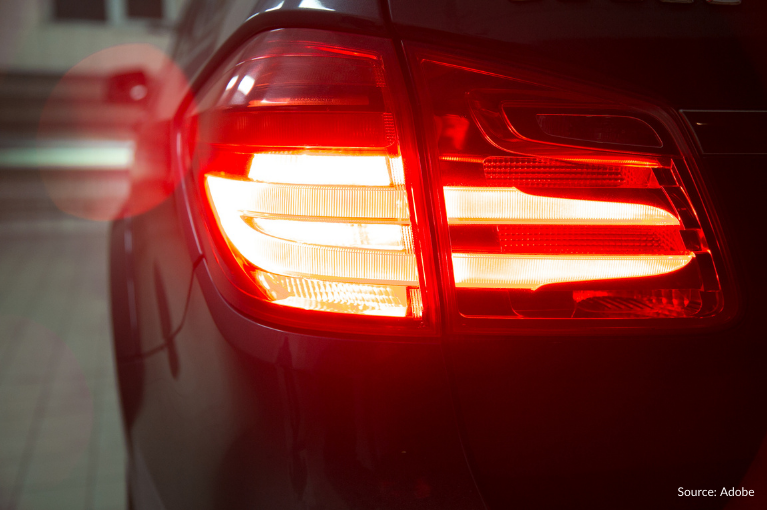 An illuminated brake light on the rear of a black vehicle. A class action lawsuit specifically targeting 2017–2018 Honda CR-V vehicles alleges that these vehicles are equipped with faulty autonomous braking systems that make the vehicles unsafe to drive.