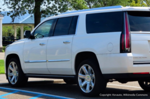 A Cadillac Escalade is parked in an outdoor parking lot.