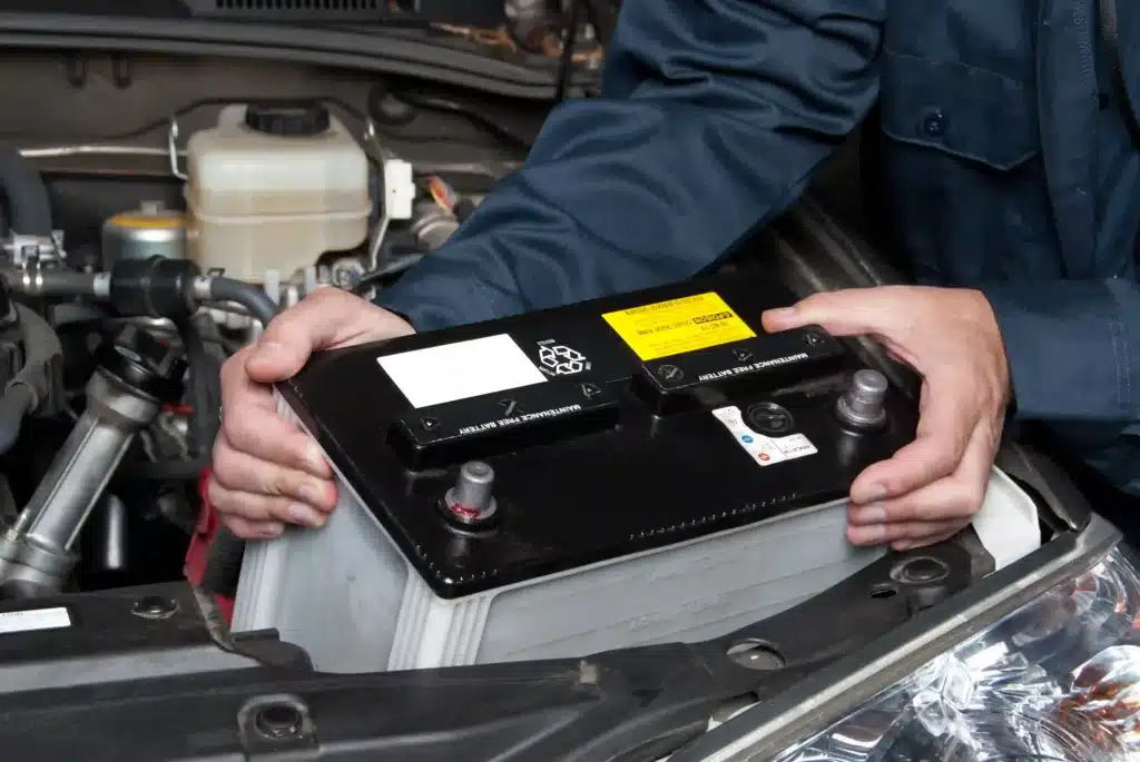 Close up of auto mechanic replacing car battery
