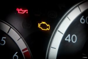 The Check Engine light and the Oil Pressure Warning light are illuminated on this close-up image of a dashboard.