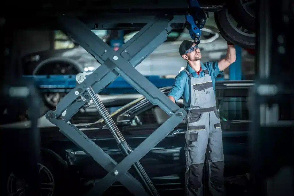 Mechanic working on car lifted in the air