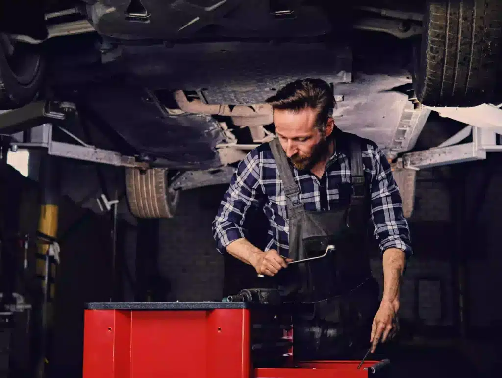 Close up of mechanic working under raised vehicle