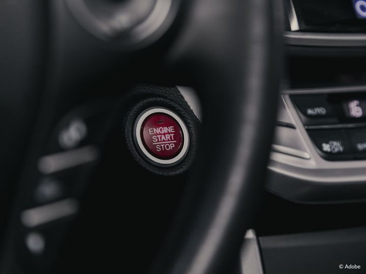 A close-up shot of a red Engine Start/Stop button in a vehicle.