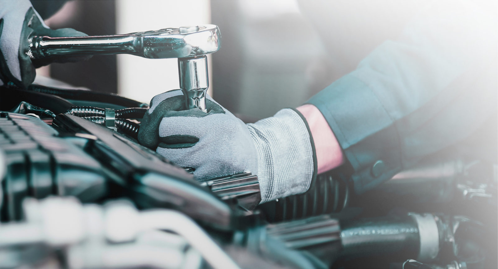 A mechanic uses a torque wrench to unscrew a bolt.