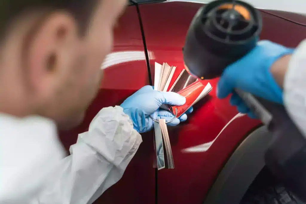 Close of of auto painter matching paint to vehicle