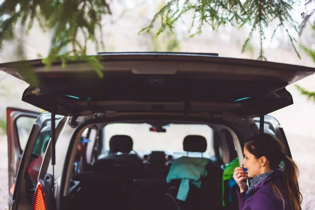 Woman standing with back hatch of vehicle open