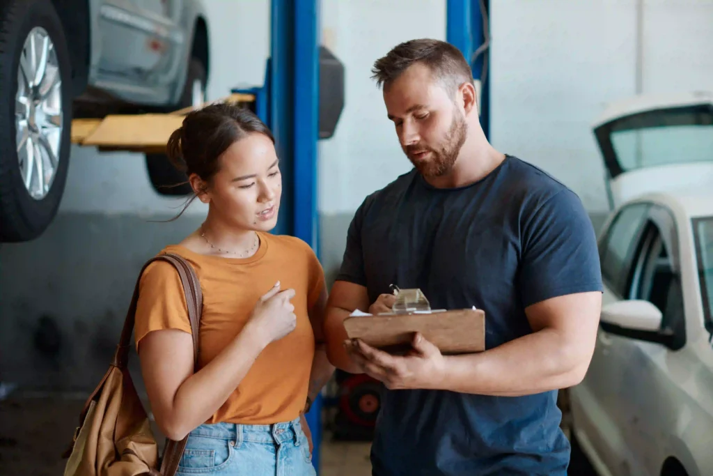 Mechanic talking to woman in service bay