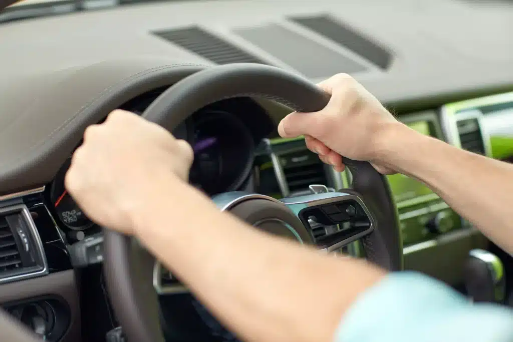 Close up of hands holding steering wheel