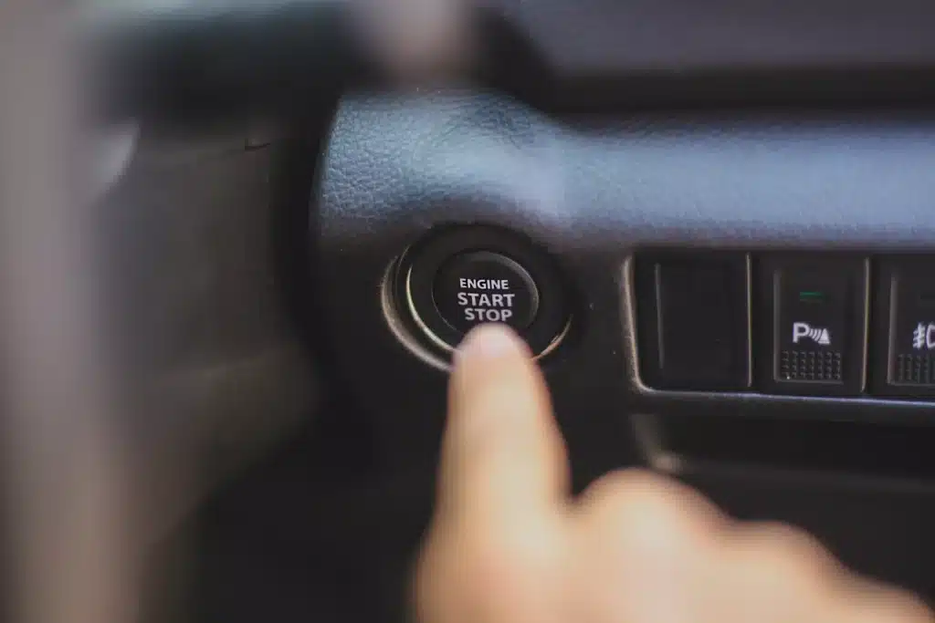 Hand pushing a start/stop engine button