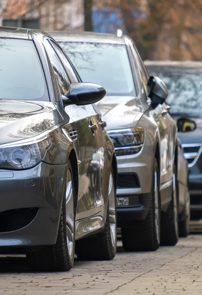 Cars parked in a row on a city street side