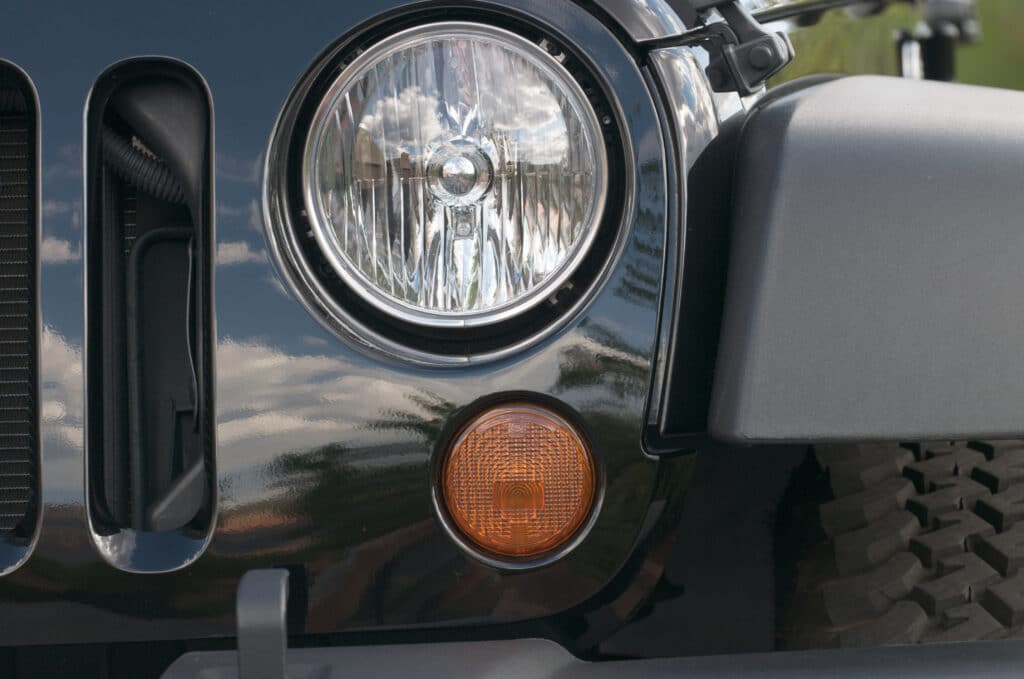 A Jeep Wrangler headlight is off. Jeep Wrangler and Grand Cherokee 4xe vehicles are being recalled for fires and loss of propulsion.